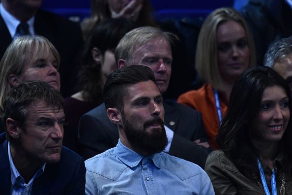 Arsenal's French football player Olivier Giroud (C) sits in the crowd to watch Novak Djokovic returns play against Britain's Andy Murray during the men's singles final on the eighth and final day of the ATP World Tour Finals tennis tournament in London on November 20, 2016. / AFP / Glyn KIRK        (Photo credit should read GLYN KIRK/AFP/Getty Images)